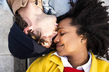 Man with eyes closed kissing girlfriend on forehead - OIPF01659