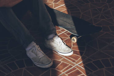 Sunlight on man's shoe and skateboard - OMIF00763