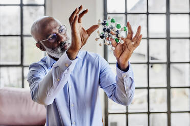 Scientist analyzing molecular model at home - FMKF07510