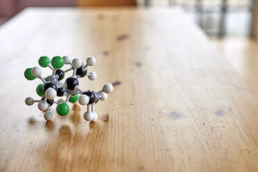 Molecular structure on wooden table - FMKF07524