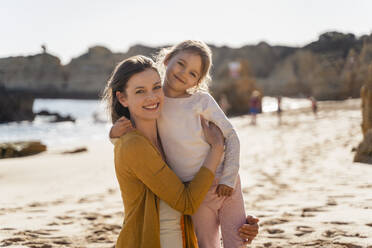 Glückliche Mutter mit Tochter am Strand an einem sonnigen Tag - DIGF17847