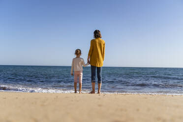 Frau mit Tochter steht am Ufer und schaut auf den Horizont - DIGF17857