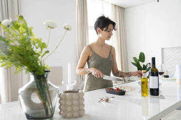 Frau bei der Zubereitung einer Mahlzeit in der Küche zu Hause - VPIF05974