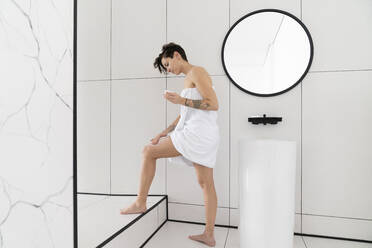 Frau trägt Feuchtigkeitscreme im Badezimmer zu Hause auf - VPIF06025