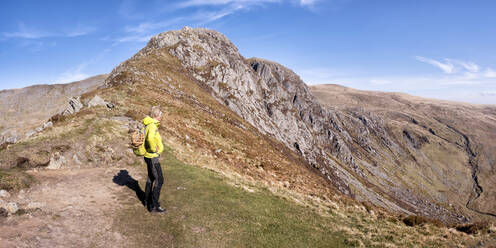 Senior woman with backpack standing on mountain - ALRF01873