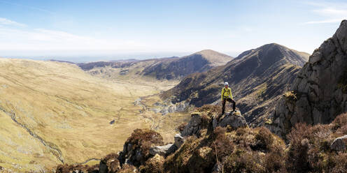 Woman standing on top of rocky cliff at sunny day - ALRF01880