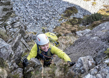 Aktive ältere Frau beim Klettern auf einen felsigen Berg - ALRF01897