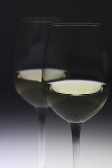 Gläser mit Weißwein vor schwarzem Hintergrund - JTF02036