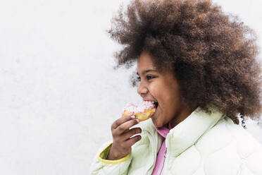 Afro girl with curly hair eating doughnut - PNAF03793