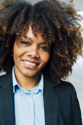 Smiling Afro businesswoman wearing suit - MEUF05391