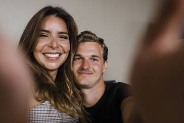 Happy young couple taking selfie in front of wall - DCRF01172