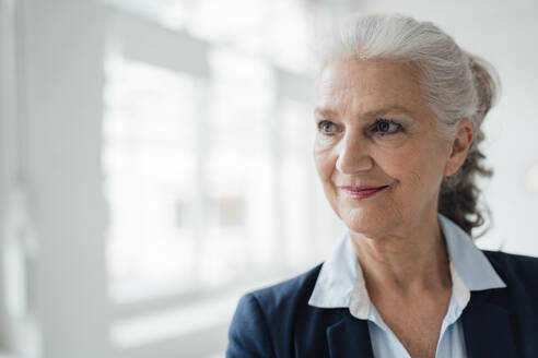 Lächelnde ältere Geschäftsfrau mit grauem Haar im Büro - JOSEF08901