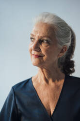 Senior woman standing against white background - JOSEF08950