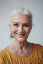 Happy senior woman with gray hair against white background - JOSEF08965