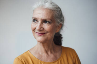 Smiling senior woman with gray hair against white background - JOSEF08966