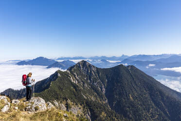 Deutschland, Bayern, Wanderin bewundert Aussicht von Berggipfel in Bayerischen Voralpen - FOF13163