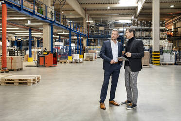Colleagues discussing in meeting at warehouse - PESF03652