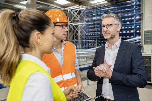 Reifer Manager plant Strategie mit Kollegen in einer Besprechung in der Fabrik - PESF03715