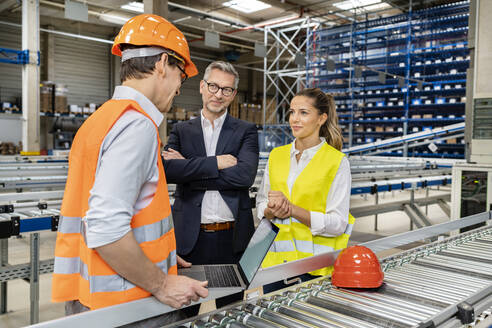 Arbeiter bespricht sich mit einem Kollegen mit dem Manager in einer Fabrik - PESF03717