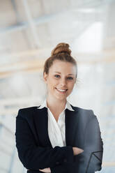 Smiling businesswoman with arms crossed at factory - JOSEF08990