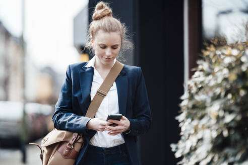 Geschäftsfrau mit Umhängetasche und Smart Phone - JOSEF08993