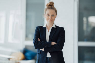 Confident businesswoman with arms crossed standing at office - JOSEF09003