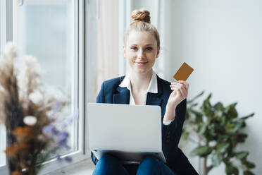 Geschäftsfrau mit Laptop und Kreditkarte im Büro - JOSEF09028