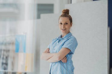 Selbstbewusster Modedesigner mit verschränkten Armen im Atelier - JOSEF09048