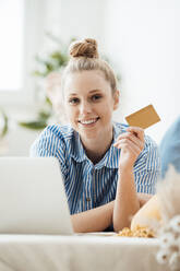 Geschäftsfrau zeigt Kreditkarte zu Hause liegend - JOSEF09063