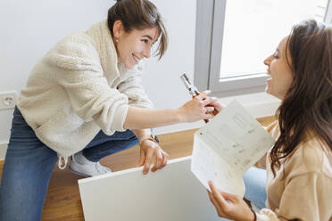 Happy young woman with lover installing furniture at new home - MRRF02064