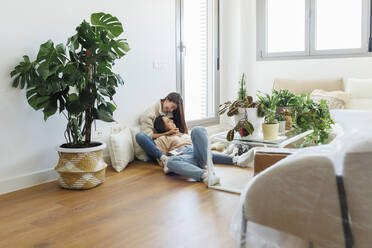 Happy lesbian couple spending leisure time together in living room at home - MRRF02071