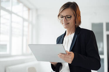 Glückliche Geschäftsfrau mit Tablet-PC im Büro - JOSEF09126