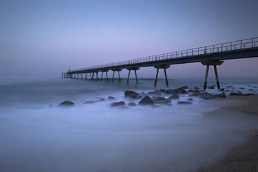 Spanien, Provinz Barcelona, Badalona, Langzeitbelichtung des Pont del Petroli-Piers in der Abenddämmerung - FCF02040