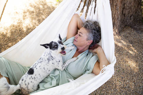 Frau mit Hund in Hängematte liegend - ESTF00090