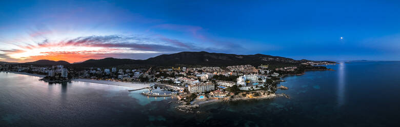 Spanien, Balearen, Santa Ponsa, Hubschrauberpanorama der Küstenstadt in der Abenddämmerung - AMF09496