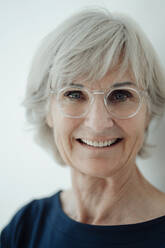 Lächelnde ältere Frau mit Brille vor weißem Hintergrund - JOSEF09348