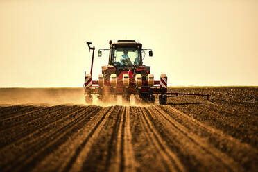 Landwirt im Traktor bei der Aussaat von Sojabohnen auf einem Ackerfeld - NOF00497