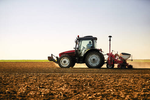 Landwirt im Traktor bei der Aussaat von Sojabohnen auf einem Feld - NOF00503