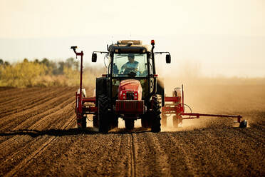 Landwirt im Traktor bei der Aussaat von Sojabohnen auf einem Acker - NOF00504