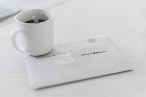 Briefwahlumschlag mit Kaffeetasse auf dem Tisch - CHPF00855