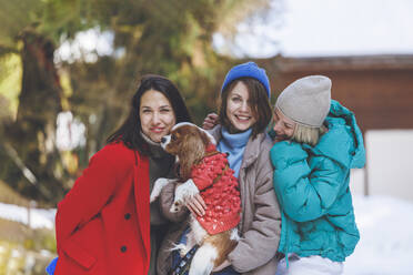 Glückliche Frauen stehen zusammen mit ihrem Hund - OMIF00783