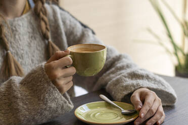 Junge Frau mit Kaffeetasse in einem Café sitzend - SSGF00902