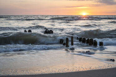 Deutschland, Schleswig-Holstein, Rantum, Strandbuhne bei Sonnenuntergang mit klarer Horizontlinie über der Nordsee im Hintergrund - KEBF02275