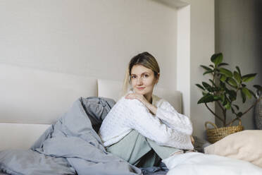 Woman sitting on bed at home in morning - SEAF00897