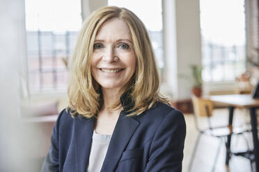 Portrait of smiling businesswoman at home - FMKF07583