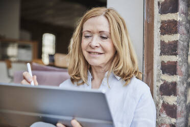 Lächelnde Geschäftsfrau mit Tablet-PC - FMKF07612