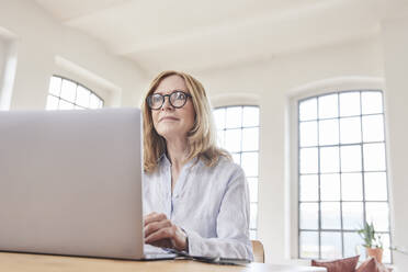 Freiberufler mit Laptop, der im Home Office arbeitet - FMKF07621