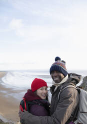 Porträt glückliches Wandererpaar oberhalb des Meeresstrandes - CAIF32347