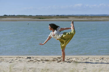 Junge Frau tanzt am Ufer des Strandes - KIJF04460