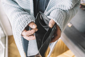 Hände eines in eine Decke eingewickelten Mannes mit leerer Brieftasche - KMKF01839